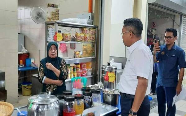 Jalaluddin (kanan) bertanya khabar penjaja di Anjung Selera Jalan Jujur Bandar Tun Razak pada Rabu.