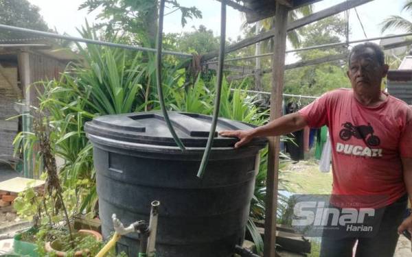 Anuar menunjukkan tangki air yang digunakan untuk menyimpan air.