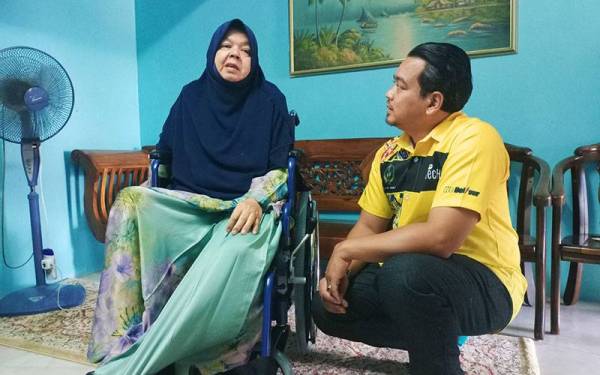 Ahmad Saidi menyantuni Hasliza ketika kunjungan ke rumahnya menyampaikan bantuan alatan pemulihan Program Skuad Perkeso Prihatin pada Khamis.