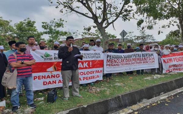 Mohd Fahmi (depan) bersama kira-kira 200 orang penduduk mengadakan bantahan aman cadangan projek pembinaan taman perindustrian di Bertam, Kepala Batas pada Jumaat.