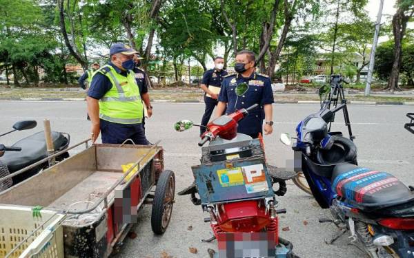 Aedy Fadly (kanan) ketika memeriksa motosikal yang disita menerusi Op Pewa di Persiaran Budiman, Shah Alam baru-baru ini.