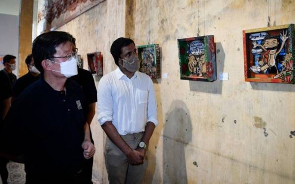 Kon Yeow (kiri) membuat lawatan ke pameran selepas merasmikan George Town Festival di Hin Bus Depot pada Sabtu. - Foto Bernama 