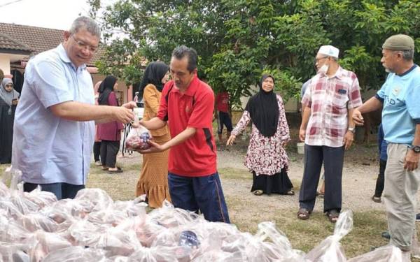 Saifuddin mengagihkan daging korban kepada penduduk di sekitar Kampung Sungai Karang pada program penyembelihan dan pengagihan daging korban di Sungai Karang di sini pada Isnin.