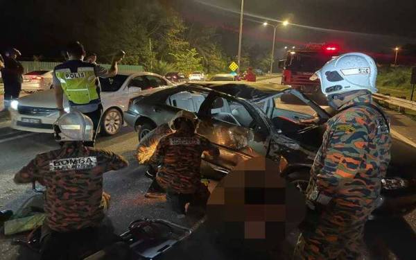 Anggota bomba membantu mengeluarkan mangsa yang tersepit di bawah kenderaan.