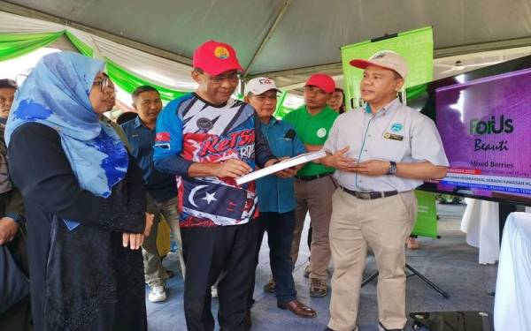 Takiyuddin (tengah) ketika melawat ruang pameran yang disediakan sempena program Mesra Rakyat Keluarga Malaysia (zon tengah) Kementerian Tenaga dan Sumber Asli di Padang Dewan Serbaguna Sungai Kerang dekat Trong di sini pada Selasa.