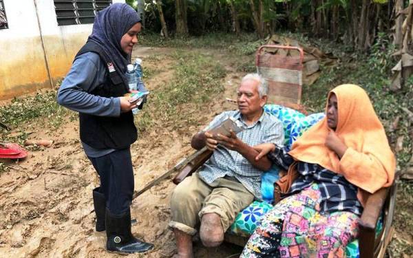 Sukarelawan mengagihkan pek korban kepada mangsa banjir.