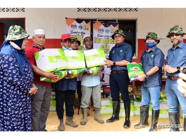 Mohd Salim menyampaikan sumbangan pek makanan kepada mangsa banjir dalam kalangan pekebun kecil.