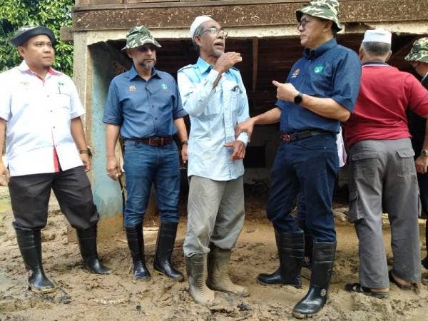Mohd Salim bersama salah seorang mangsa, Abdullah Ahmad, 65, di Kampung Masjid Iboi, Kupang, Baling ketika mengadakan lawatan kerja pada Rabu.