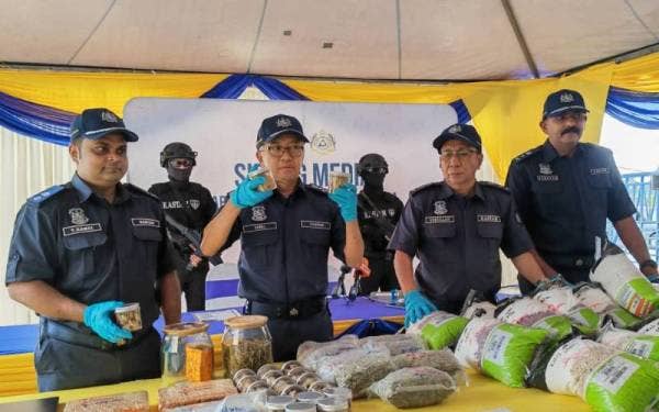 Zazuli(dua dari kiri) menunjukkan balang biskut kanabis yang dijual di media sosial