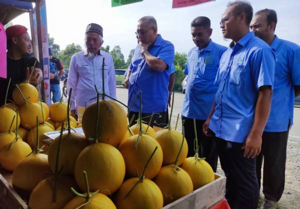 Zainal Abidin (empat dari kanan) melihat buah melon yang dijual seorang usahawan pada Program Khas JTDLKM yang diadakan di Tapak Pasar Malam Medan Jaya, Rusila, Marang.