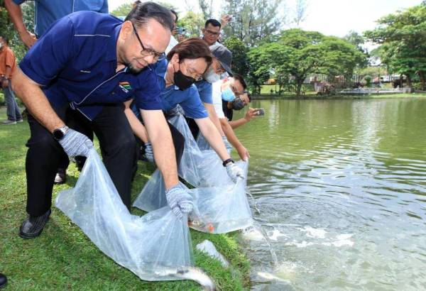 Rizalman (kiri) melepaskan ikan koi ke dalam Tasik Permaisuri simbolik pada Majlis Pra Pelancaran Karnival Bersamamu.