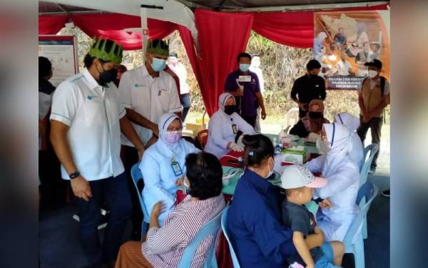 Khairy Jamaluddin (kiri) meninjau pemeriksaan kesihatan pada Majlis Perasmian dan Pelancaran Tinjauan Kesihatan Orang Asli di Dewan Komuniti Sahom pada Sabtu.