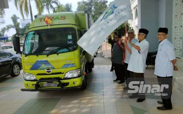 Abdul Aziz (dua kanan) melakukan gimik pelepasan konvoi Misi Bantuan Pasca Banjir MAIS dan anak syarikat ke Baling, Kedah di Bangunan Sultan Idris Shah.