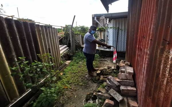 Kamarul Azman menunjukkan sebuah rumah penduduk yang telah memasuki tanah orang lain.