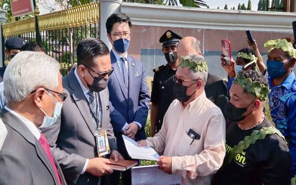 Dahil (depan, dua dari kanan) menyerahkan dua memorandum membantah pembalakan di wilayah tanah adat Orang Asli Perak kepada Azlan (dua dari kiri).