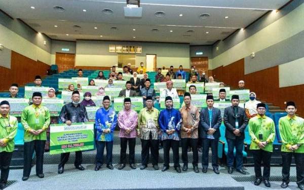 Ketua Pegawai Eksekutil Muip, Datuk Ahmad Hairi Husain (lapan, kanan) bersama penerima dalam satu program agihan sumbangan.