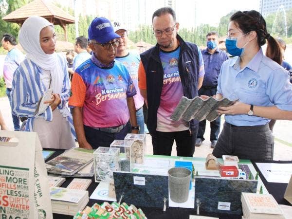 Ismail (dua dari kiri) diiringi Rizalman melawat tapak pameran kitar semula.