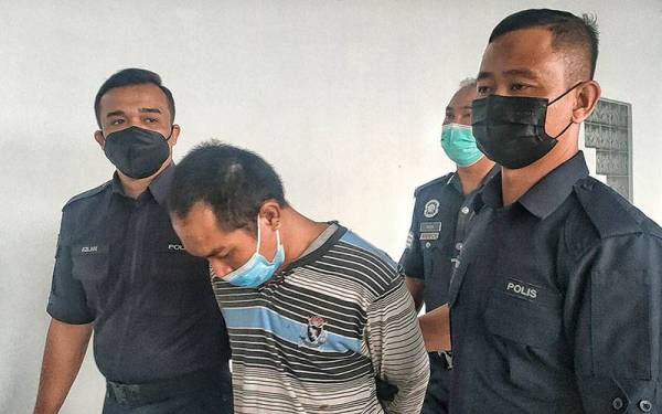 Tertuduh (dua dari kiri) ketika dibawa keluar dari Mahkamah Majistret Melaka, pada Rabu.