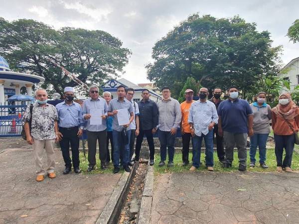 Fahmi (empat dari kiri) bersama kepimpinan PKR Pulau Pinang daripada pelbagai cabang menunjukkan laporan polis yang dibuat terhadap Najib pada Selasa.