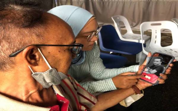 Harris dan Siti Hadilah sebak melihat gambar arwah Mohd Haziq, namun reda dengan pemergian anak mereka itu.