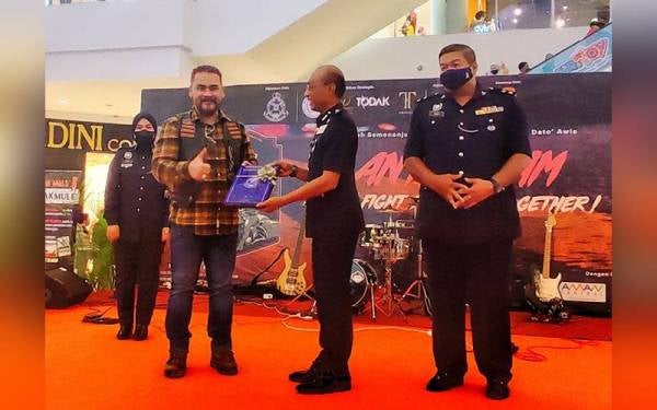 Timbalan Ketua Polis Kedah, Datuk Mohd Roze Shaari (tengah) menyerahkan cenderahati kepada Awie pada Kempen Pencegahan Jenayah Anti Scam Polis Diraja Malaysia (Awie Tour) Tahun 2022 di Aman Central, di sini, pada Selasa.