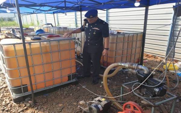Ahmad Khuzairi melihat tangki petak mengandungi diesel bersubsidi yang ditemui dalam serbuan di sebuah premis di kawasan Perindustrian Mahsan pada Isnin. Foto: KPDNHEP Kuala Pilah