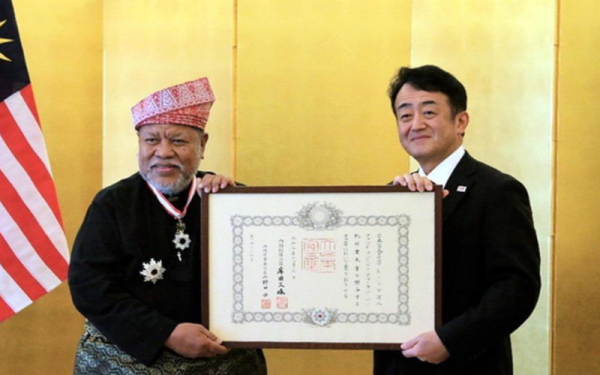Takahashi (kanan) menyampaikan anugerah 'Order of the Rising Sun, Gold and Silver Star' daripada Maharaja Jepun kepada Ahmad Puzi di atas sumbangannya kepada keselamatan maritim. - Foto Berrnama