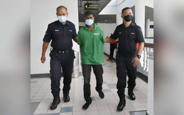 Nagaraj (tengah) ketika dibawa keluar dari Mahkamah Majistret Melaka, pada Khamis.