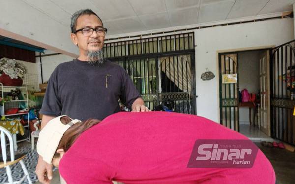 Adzmarudin menunjukkan keadaan belakang anaknya.