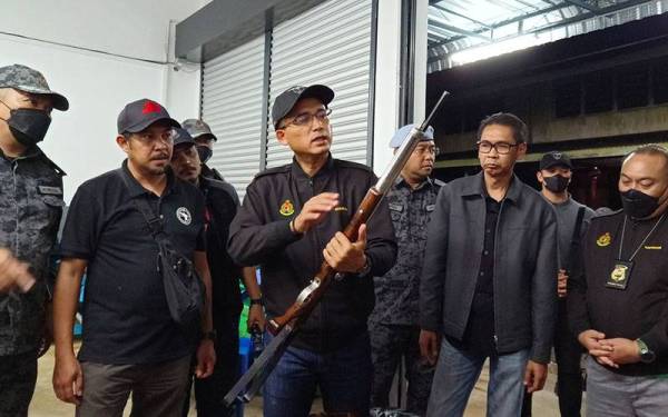 Khairul Dzaimee menunjukkan senapang angin yang dirampas pasukan serbuan di Kuala Gula.
