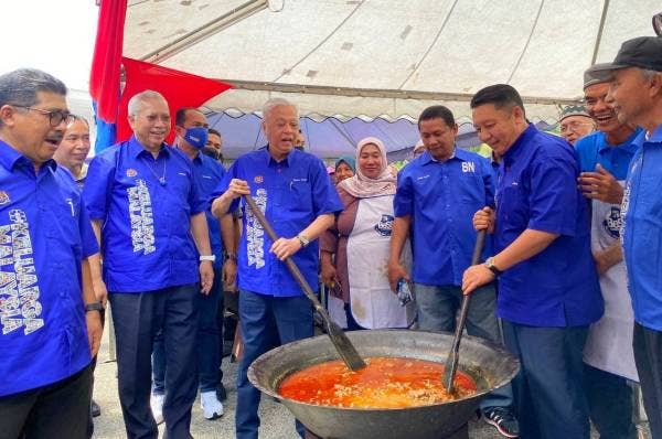 Ismail Sabri (tiga dari kiri) meluangkan masa mengacau gulai semasa hadir program ‘bekwoh’ di Kompleks Yayasan Kemiskinan Kelantan (YKK) Peringat di Kota Bharu pada Sabtu.