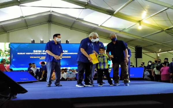 Hamzah (dua dari kiri) menyerahkan Surat Kelulusan kepada penerima selepas Sesi Town Hall sempena Program Kita Demi Negara Zon Utara di Dewan Astaka, Batu Kurau, Larut pada Sabtu.