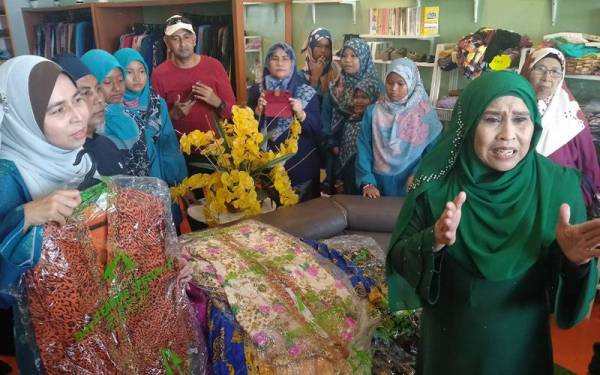 Kartina (kanan) ketika menyerahkan kira-kira 30 pasang koleksi kebaya peribadi yang digayakan menerusi watak Mami Jarum pada 2002.