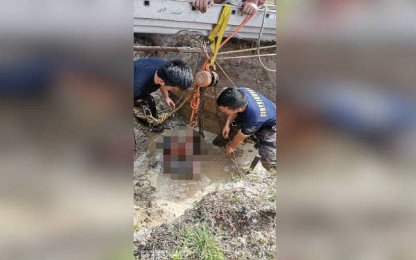 Anggota bomba membantu mengeluarkan mangsa yang tertimbus dalam runtuhan tanah di sebuah sekolah di Bandar Penawar, Kota Tinggi pada Ahad.