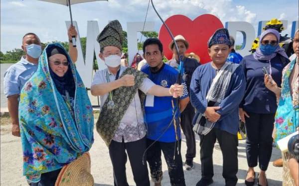 Kon Yeow (dua dari kiri) mencuba aktiviti memanah pada Pesta Padi Antarabangsa Pulau Pinang 4.0 yang dianjurkan di Kampung Terus, Penanti pada Ahad.