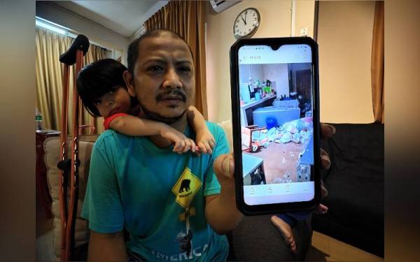 Mohd Faizal menunjukkan gambar keadaan rumah sewanya ketika dinaiki air.