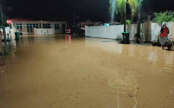Keadaan banjir kilat di sebuah taman perumahan di Daerah Yan pada Ahad. - Foto media sosial