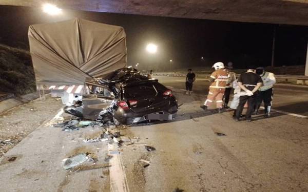Anggota bomba membantu mengeluarkan mayat mangsa dalam kemalangan di KM126 LPT1 di Temerloh pada awal pagi Khamis. - Foto ihsan JBPM