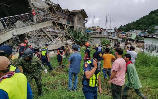 Pasukan penyelamat berada di lokasi bangunan runtuh di La Trinidad, wilayah Bunguet pada Rabu akibat gempa bumi di utara Filipina. - Foto AFP/La Trinidad Municipal Police Station