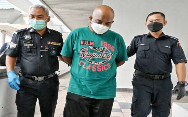 Danial Dallas (tengah) ketika dibawa keluar dari Mahkamah Majistret Melaka pada Jumaat.