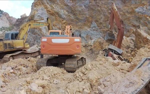 Pemandu ekskavator (kanan) dipercayai tertimbus di tapak pembinaan selepas berlaku runtuhan tanah pada pagi Sabtu.