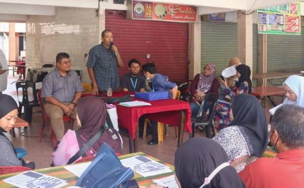 Pengerusi Persatuan Penjaja dan Peniaga Kecil Cawangan Kota Setar, Mohd Kholib Hamid (tengah) memberi taklimat kepada peniaga di Medan Selera Mergong pada Rabu lepas.