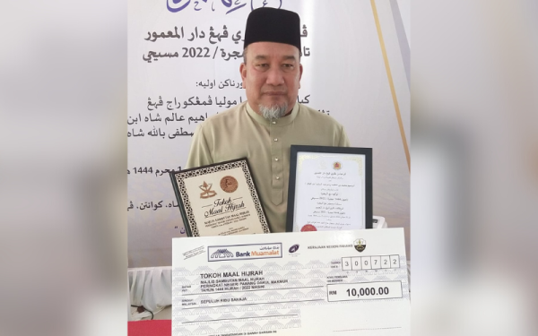 Mohd Alhamadi bersama Sijil Tokoh Maal Hijrah dan replika cek yang diterimanya bagi pihak Mat Kilau.