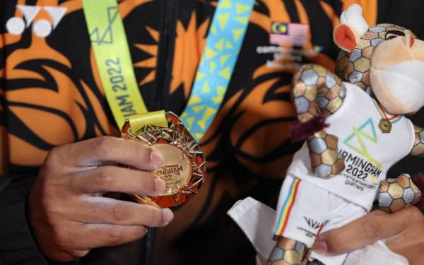 Emas pertama...Atlet angkat berat negara Mohamad Aniq Kasdan menunjukan pingat emas pertama negara dalam kategori 55kg pada Sukan Komanwel Birmingham 2022 di Dewan NEC 1, pada Sabtu. - Foto Bernama