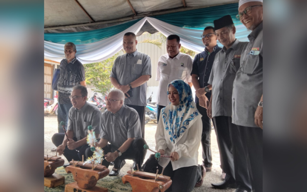 Zamri (duduk, tengah) mencuba permainan tradisional kertuk sebelum merasmikan Mesyuarat Agong Tahunan Pertubuhan Peladang Kawasan Kangkong Pasir Mas, pada Ahad.