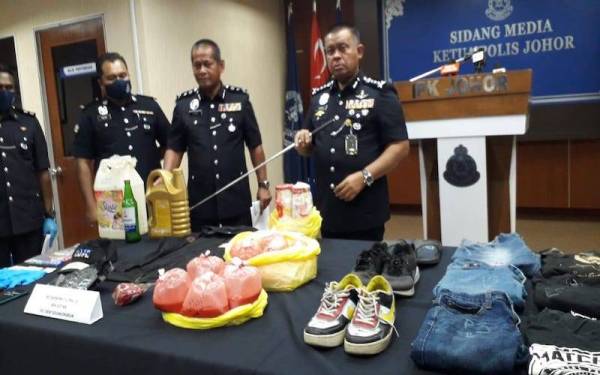 Kamarul Zaman menunjukkan barang-barang yang dirampas selepas menahan 11 ahli sindiket ah long pada sidang akhbar di IPK Johor, Johor Bahru, pada Ahad