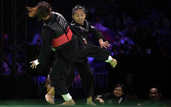 Nor Farah (kanan) ketika beraksi menentang pesilat dari Singapura Nadhrah Sahrin pada perlawanan akhir Tanding kategori A Wanita. Foto Bernama