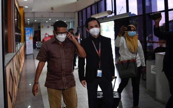 Govindarajoo diiringi pegawai SPRM ketika hadir ke mahkamah pada Isnin.