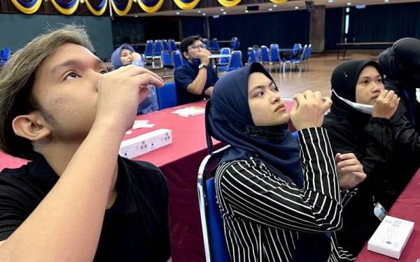 Pelajar Universiti Malaya menggunakan kit ujian percuma daripada MR D.I.Y.