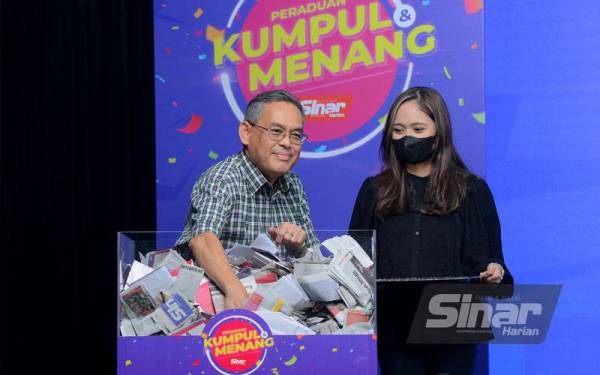 Rozaid melakukan cabutan bagi memilih pemenang Hadiah Utama Peraduan Kumpul dan Menang Sinar Harian Edisi Ketiga pada Ahad. - Foto Sinar Harian/MOHD HALIM ABDUL WAHID